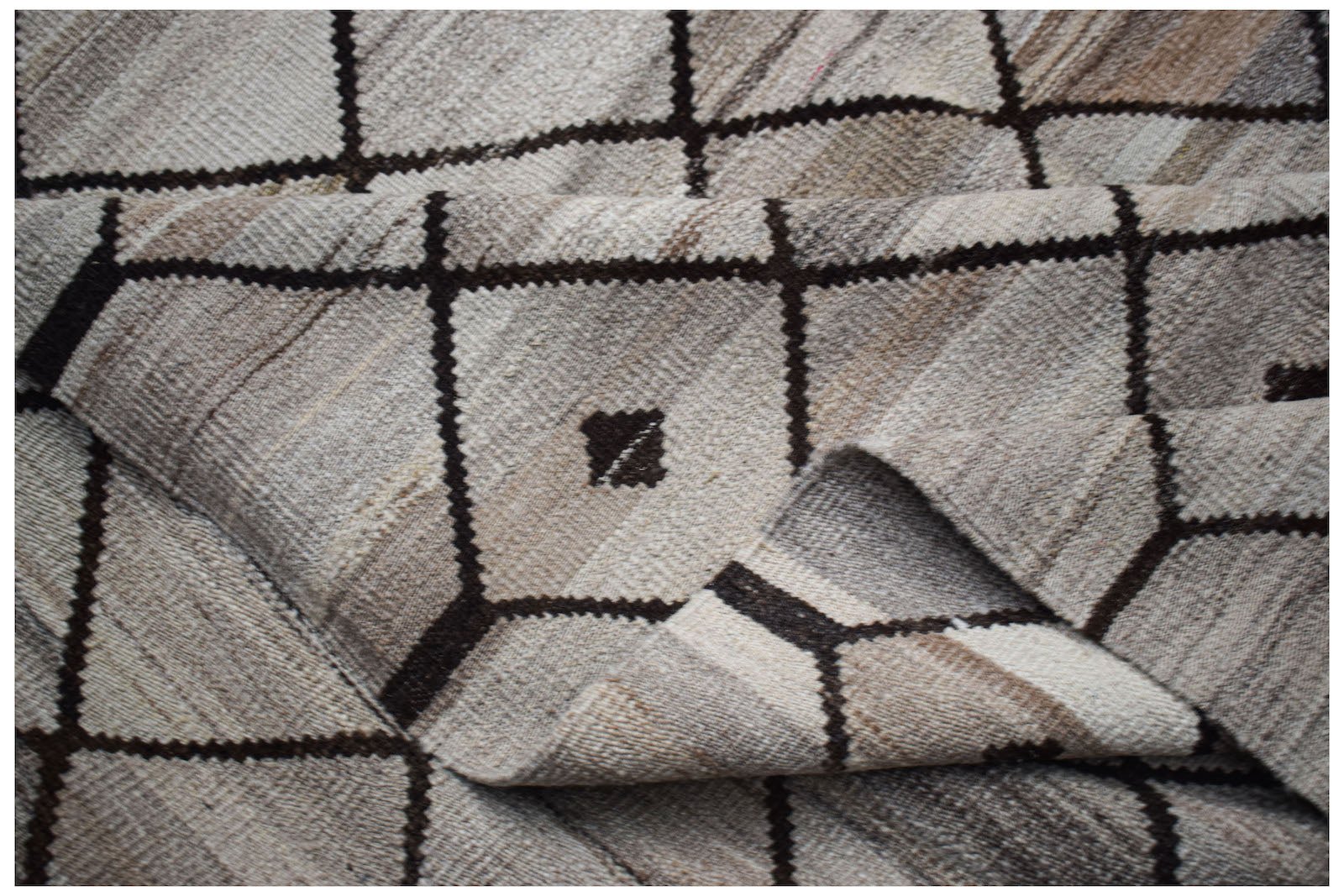 A handmade Afghan Maimana kilim featuring a neutral geometric grid pattern with small dark accents.