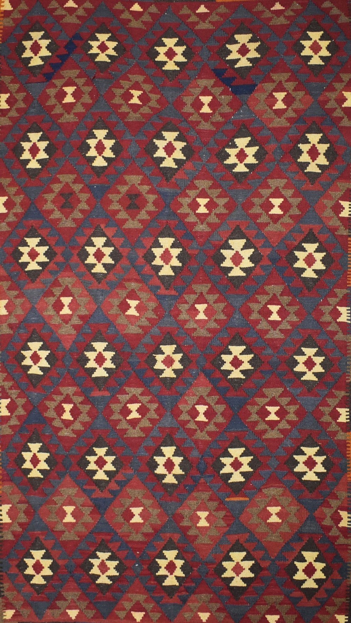 Handmade Afghan Maimana kilim rug featuring a repeating diamond pattern in red, blue, and cream.