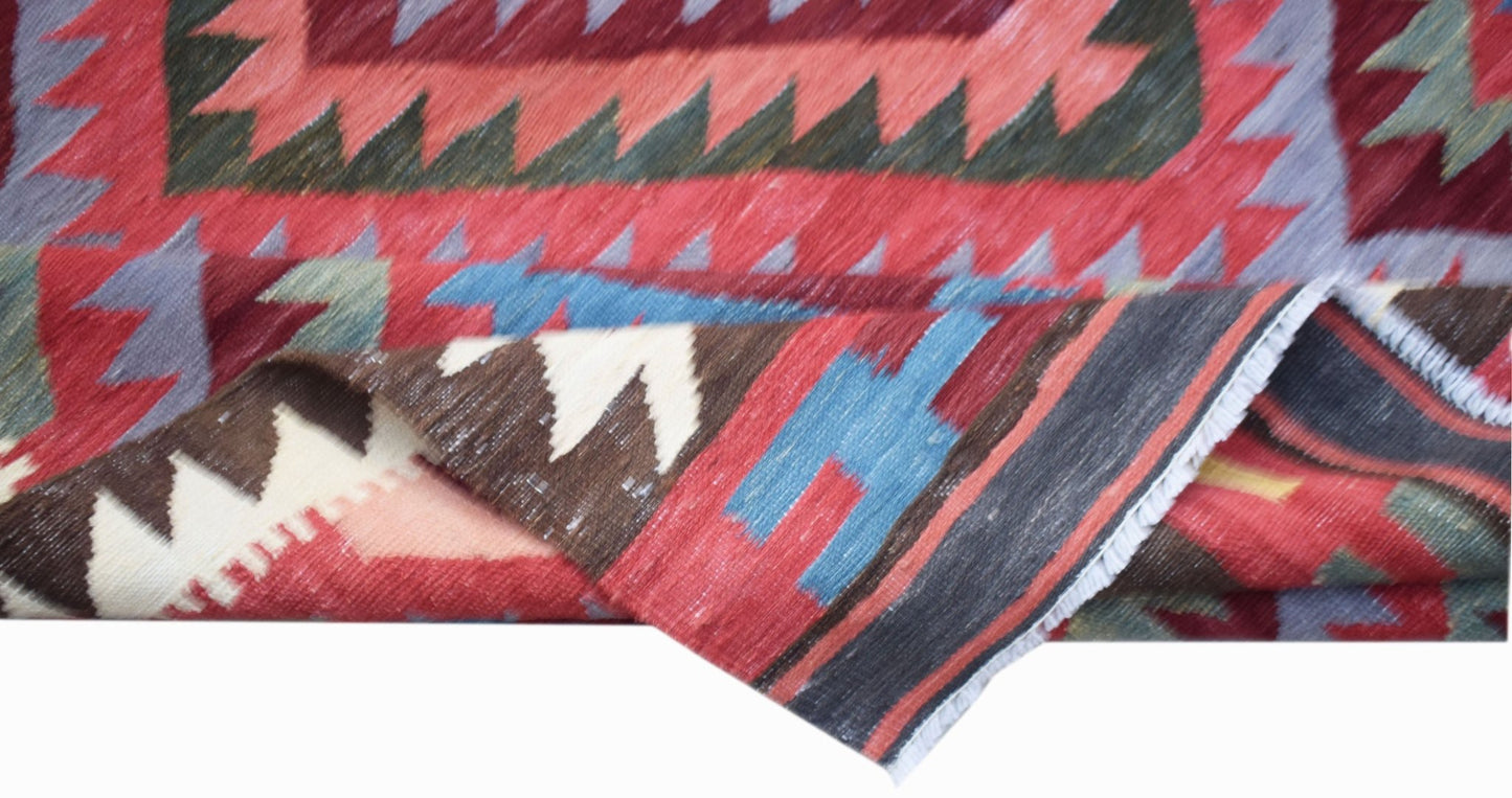 Handwoven Afghan Maimana kilim rug featuring a geometric pattern in vibrant wool colors.