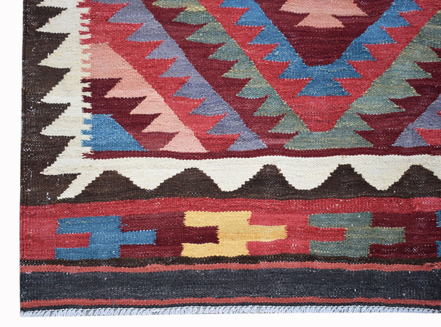 Handwoven Afghan Maimana kilim rug featuring geometric patterns in red, blue, yellow, and brown.