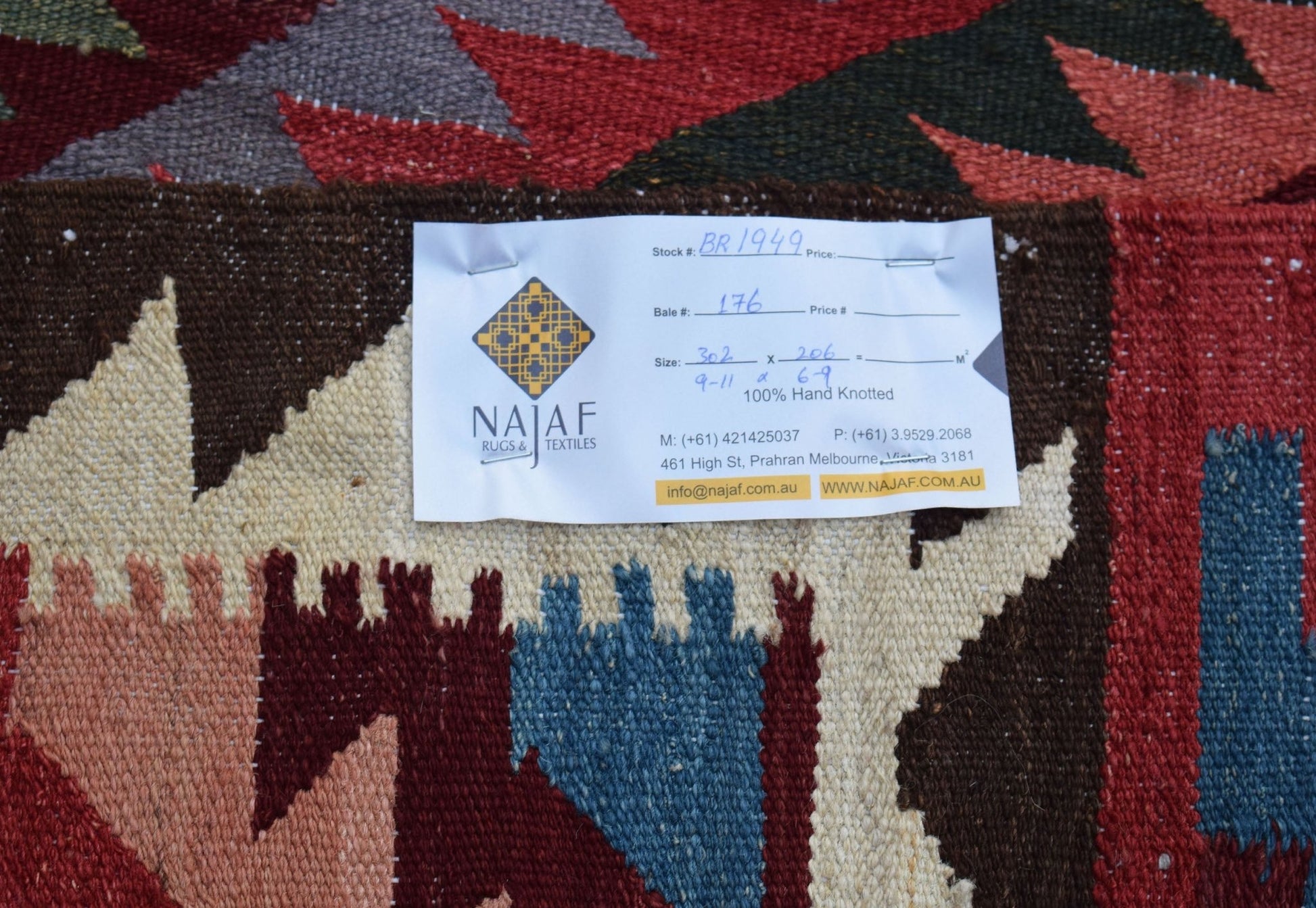 A handmade Afghan Maimana kilim featuring a geometric pattern in red, blue, and cream tones.