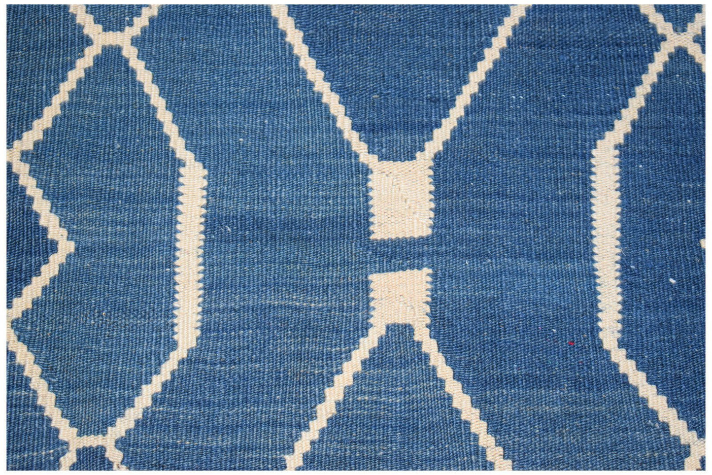 A handmade Afghan Maimana kilim featuring a blue field with a white geometric diamond pattern.