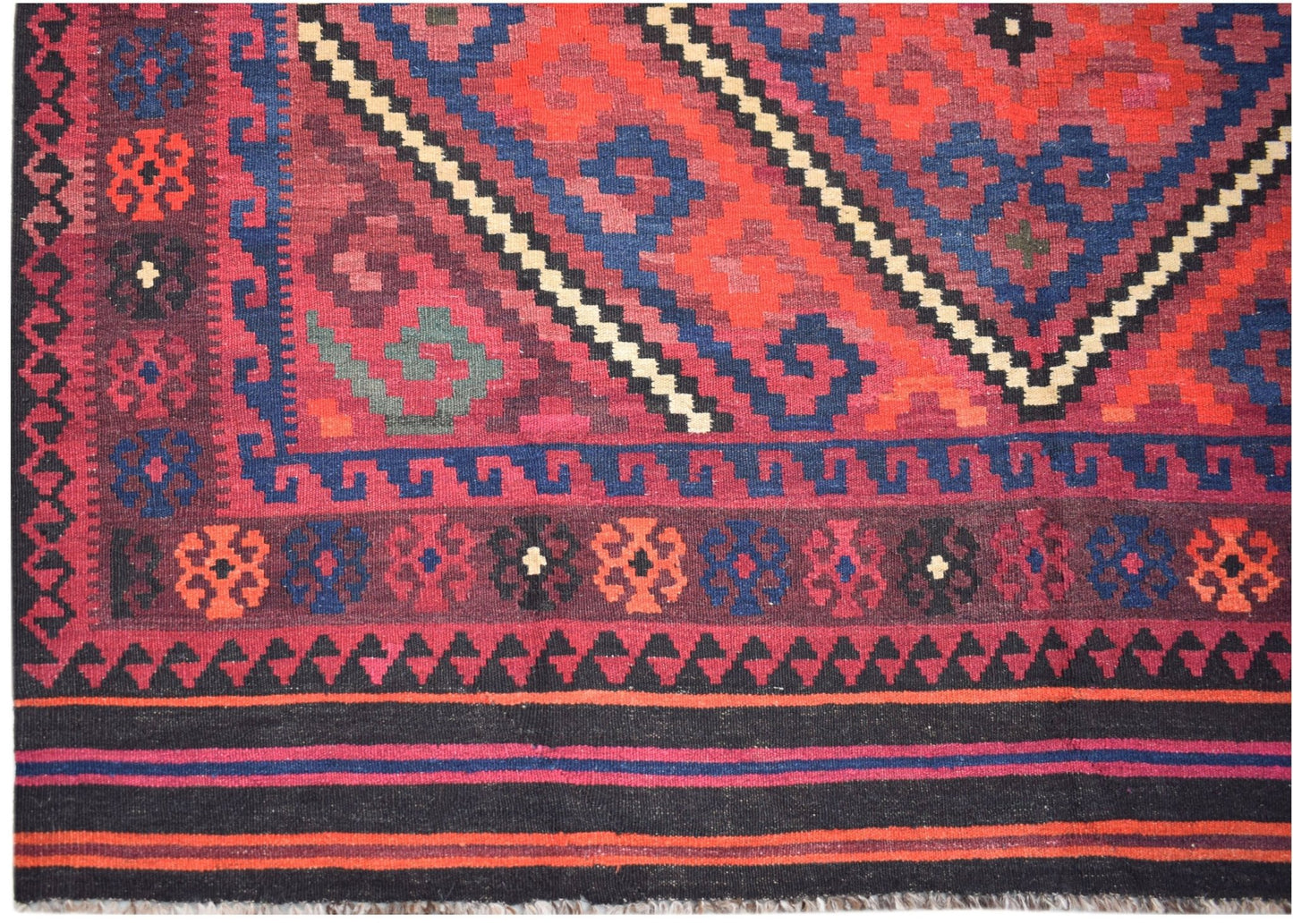 Handwoven Afghan Maimana kilim featuring geometric patterns in red, blue, and black wool.