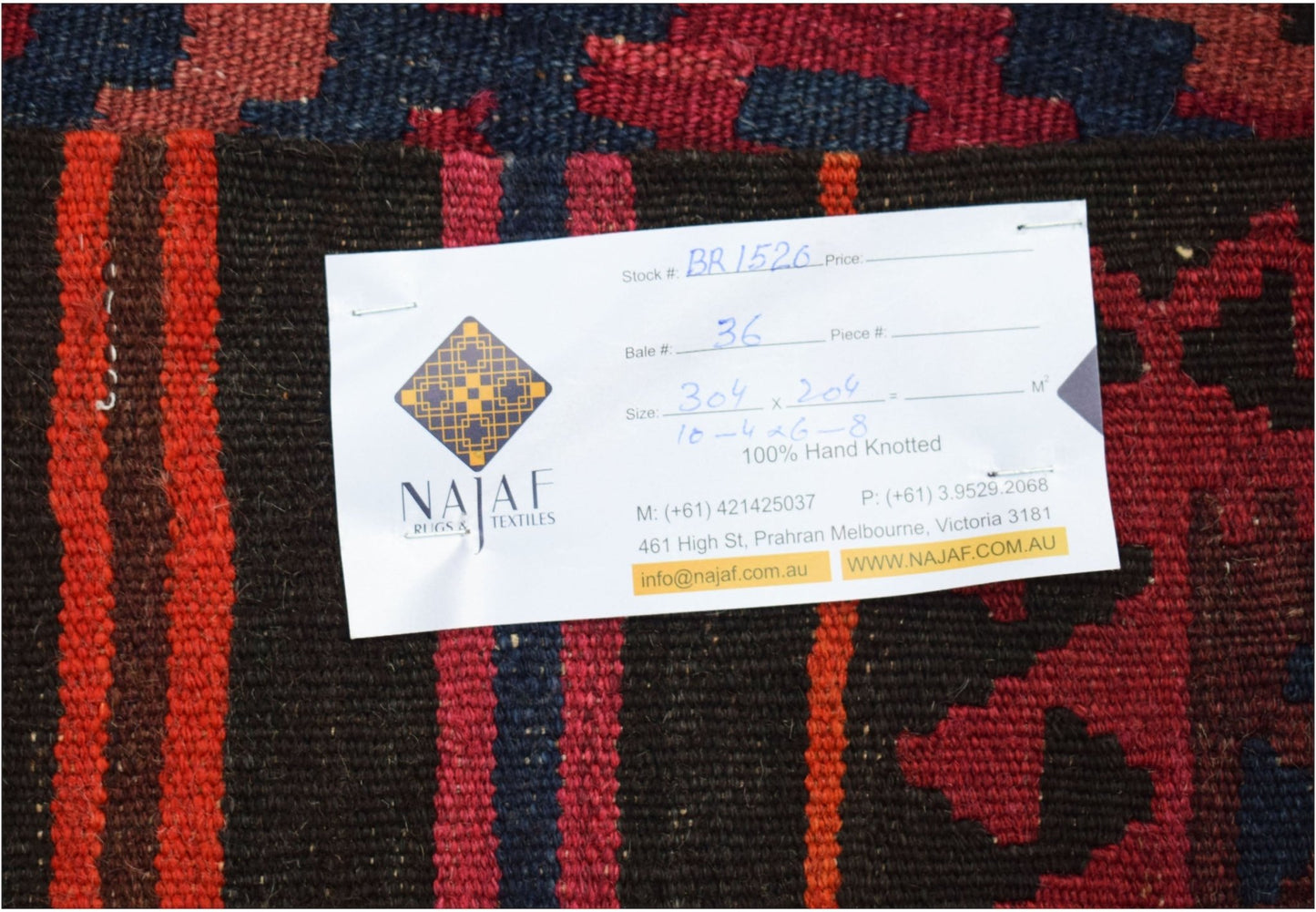 A handwoven Afghan Maimana kilim featuring a geometric pattern in deep red, blue, and brown tones.