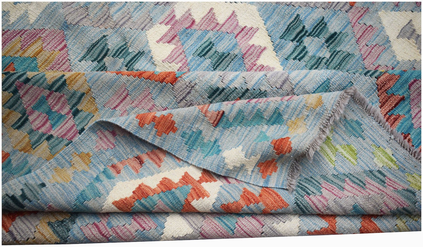 Handwoven Afghan Maimana kilim rug featuring a colorful geometric pattern on a light blue field.