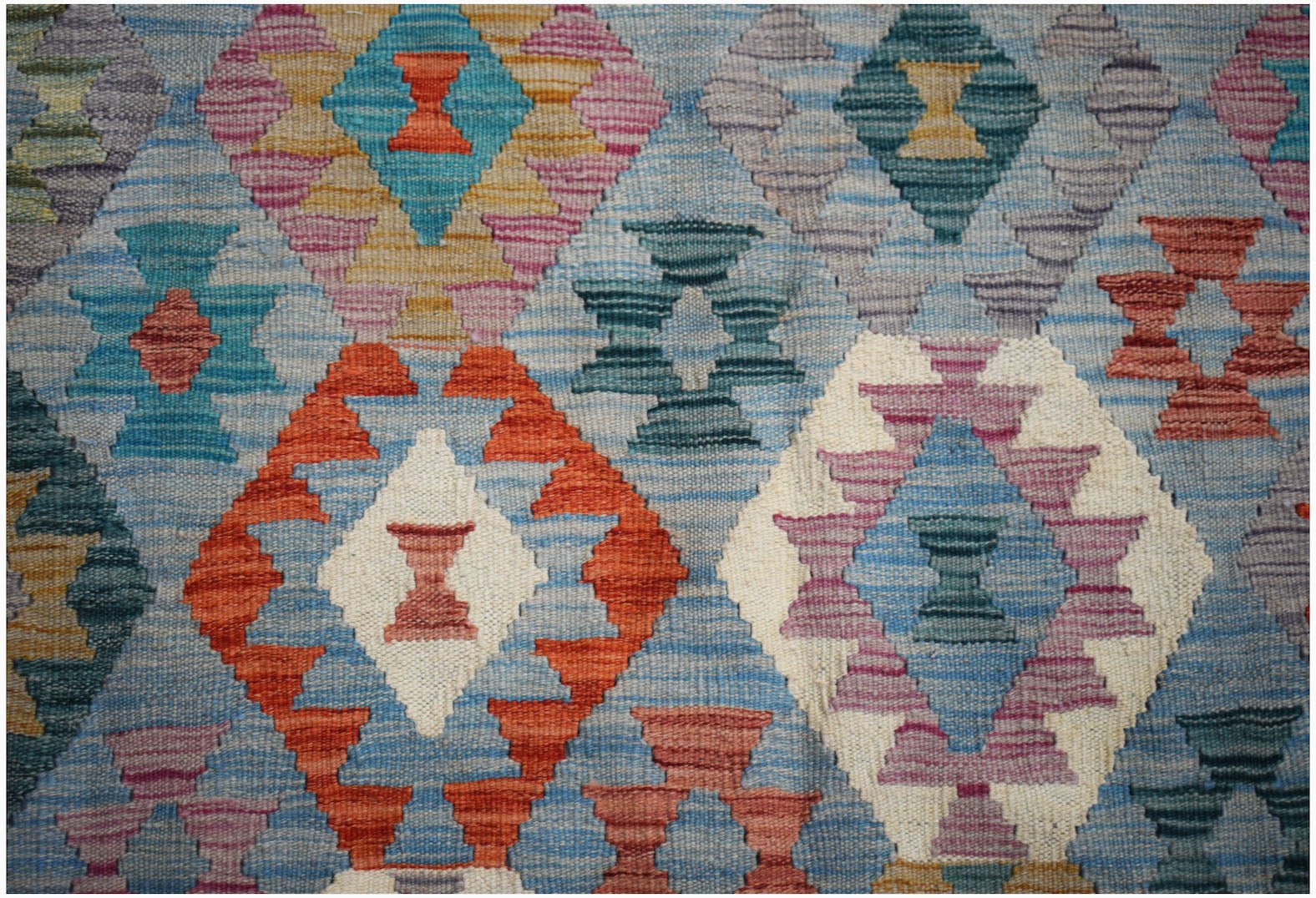 Handwoven Afghan Maimana kilim rug featuring a colorful geometric diamond pattern in wool.