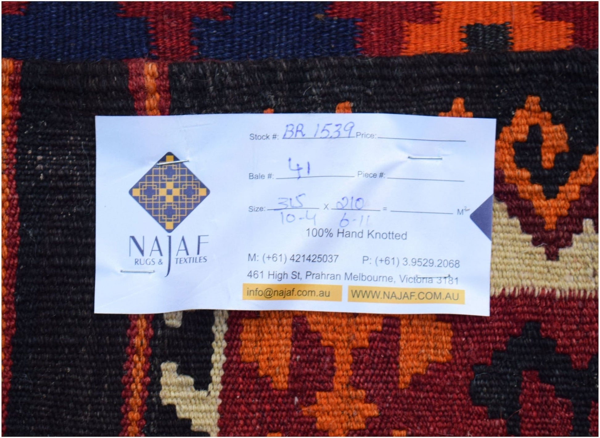 A handmade Afghan Maimana Kilim featuring a geometric pattern in red, orange, and dark blue.