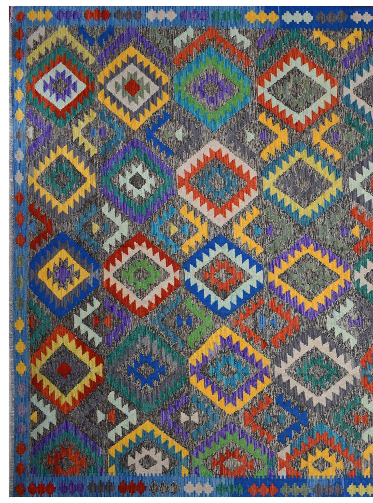 Handmade Afghan Maimana kilim rug featuring a vibrant geometric diamond pattern on a grey background.