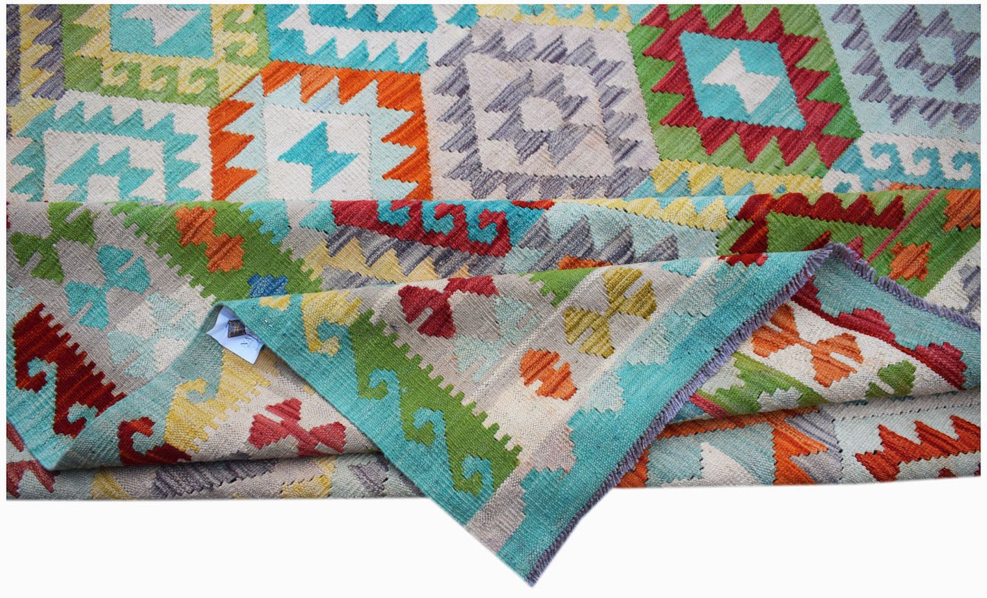A handmade Afghan Maimana kilim rug featuring a vibrant geometric pattern in wool.