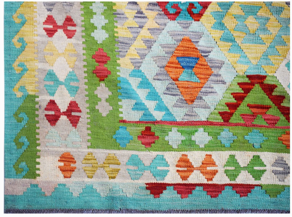 Handwoven Afghan Maimana kilim rug featuring a vibrant geometric pattern in wool.
