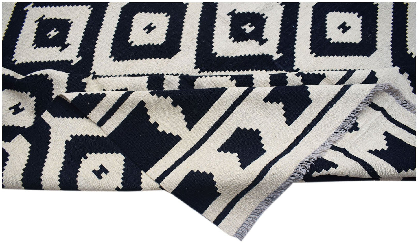 Handwoven Afghan Maimana kilim rug featuring a black and white geometric diamond pattern.