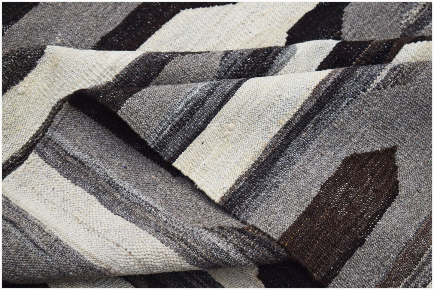 A handwoven Afghan Maimana kilim featuring a geometric pattern in natural undyed wool tones.