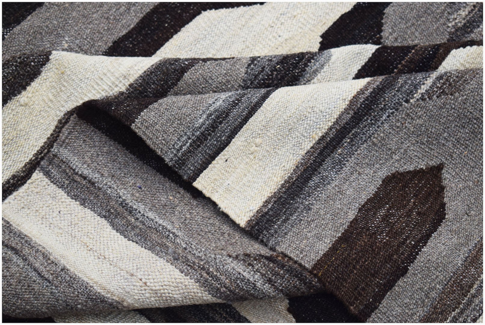 A handwoven Afghan Maimana kilim featuring a geometric pattern in natural undyed wool tones.