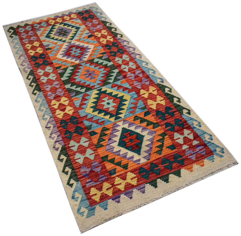 Afghan Maimana Kilim runner with geometric patterns in vibrant colors.