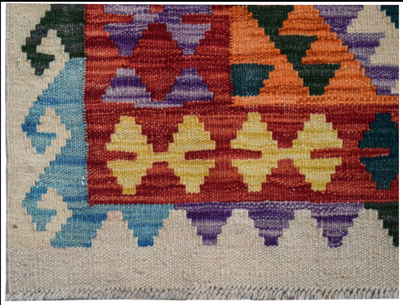 A handmade Afghan Maimana kilim runner featuring geometric patterns in vibrant, multicolored wool.