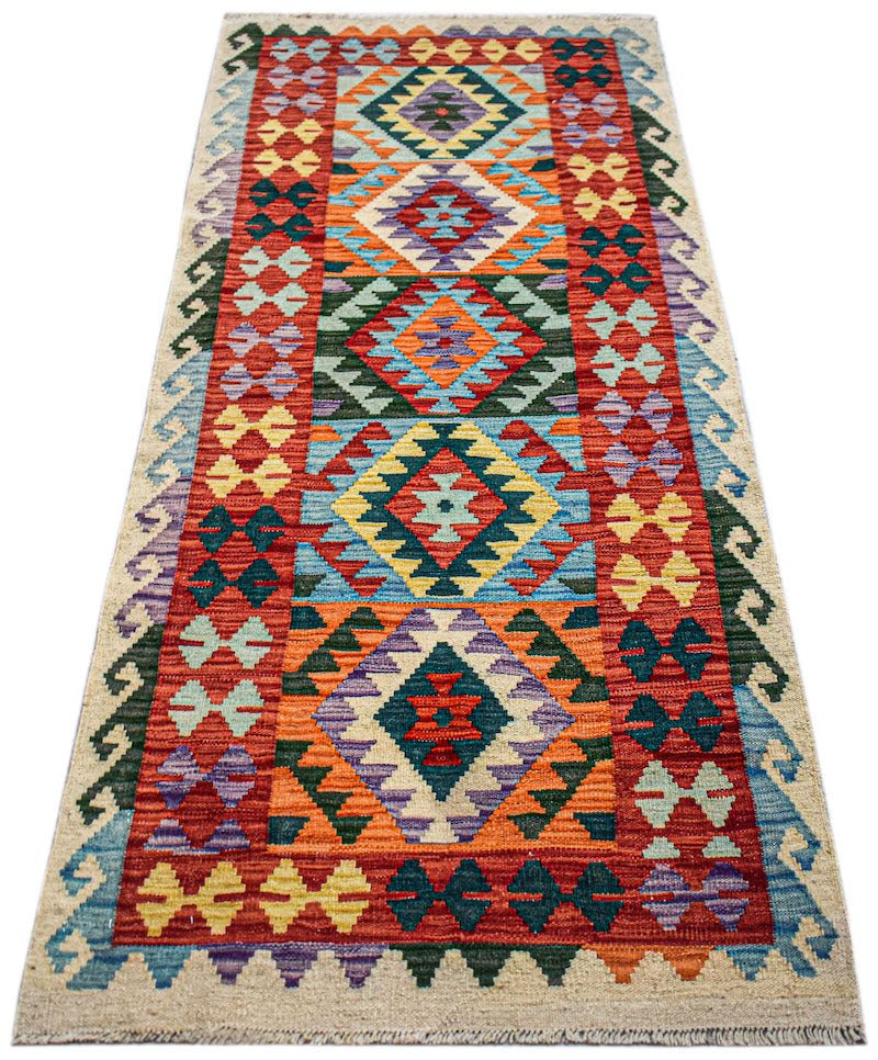 Handwoven Afghan Maimana wool runner featuring a vibrant geometric pattern in a flatweave style.