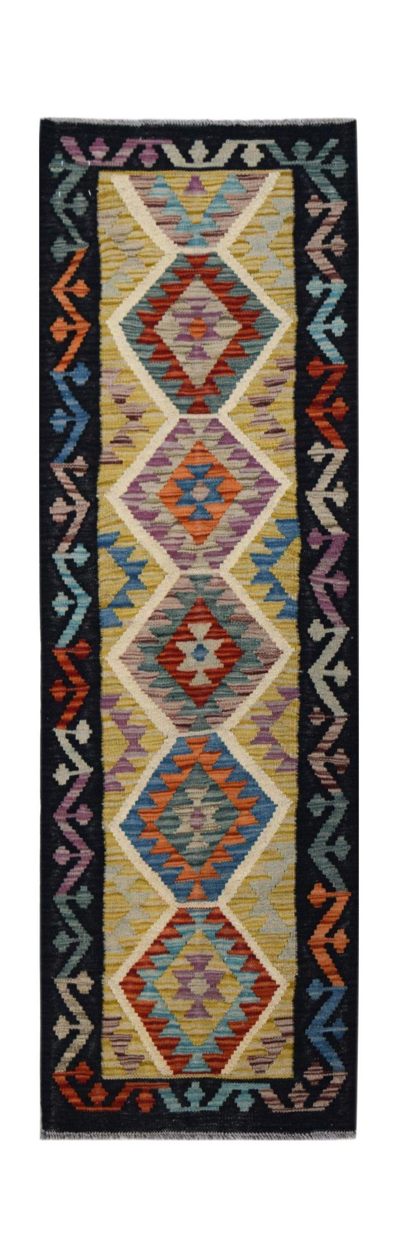 A handmade Afghan Maimana wool runner rug featuring a colorful geometric diamond pattern.