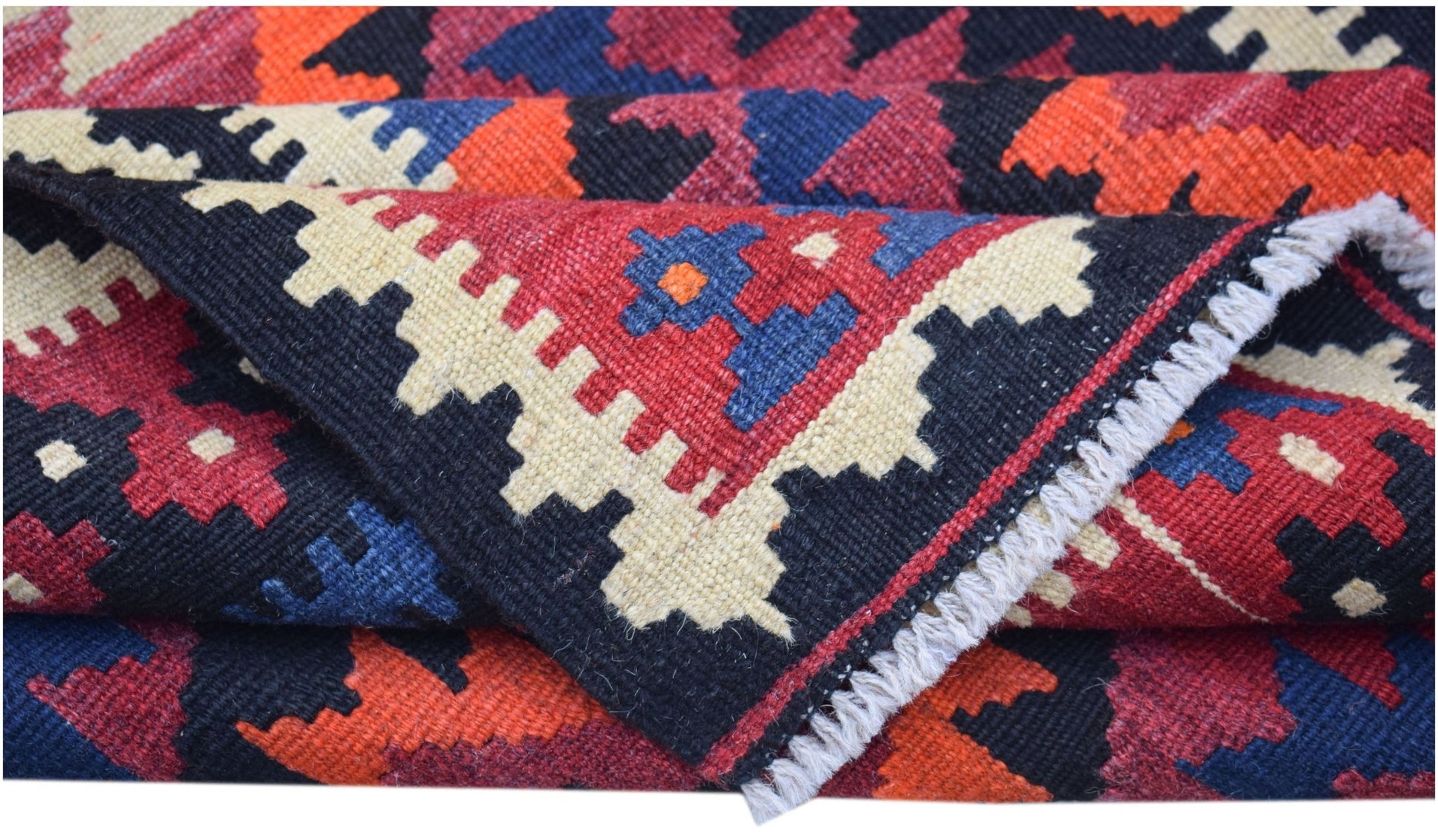 A handwoven Afghan Maimana kilim runner featuring a geometric pattern in red, blue, and cream.