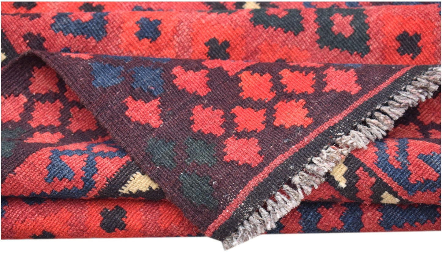 A handwoven Afghan Maimana kilim runner featuring a geometric pattern in red, black, and blue.