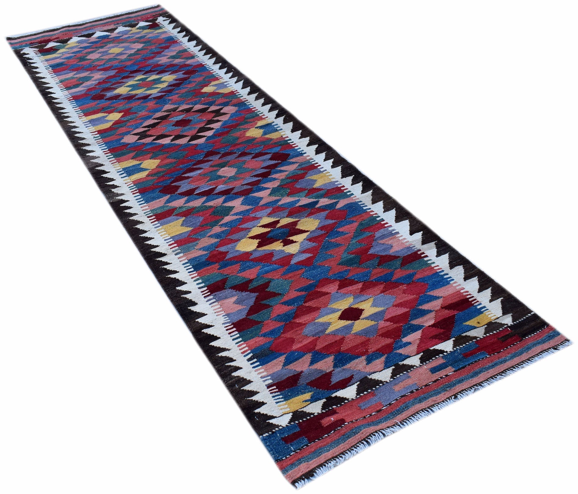 A handmade Afghan Maimana wool runner rug featuring a colorful geometric diamond pattern.