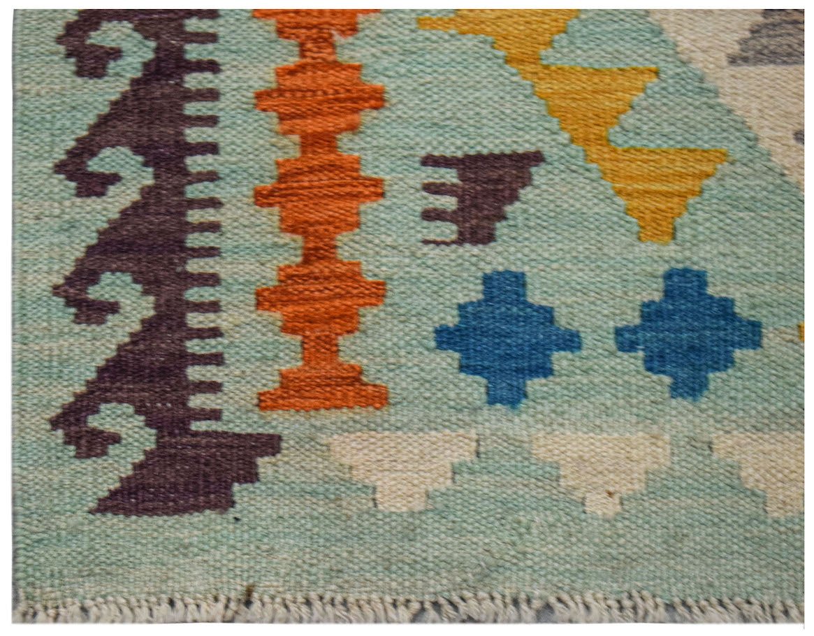 A handwoven Afghan Maimana kilim runner featuring geometric patterns in vibrant colors.