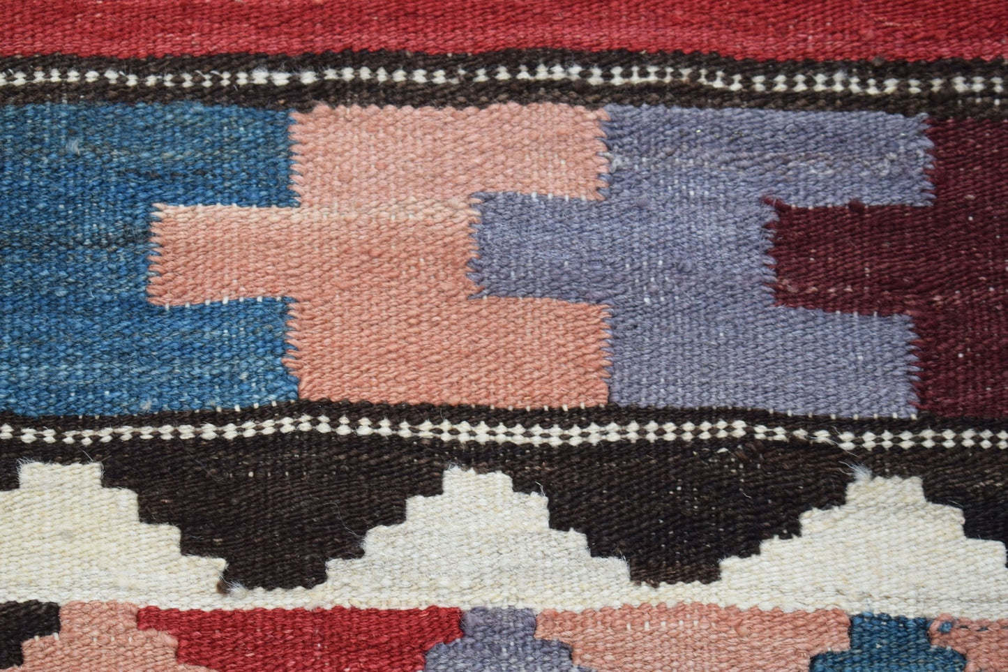 A close-up of a handmade Afghan Maimana kilim runner featuring geometric patterns in wool.