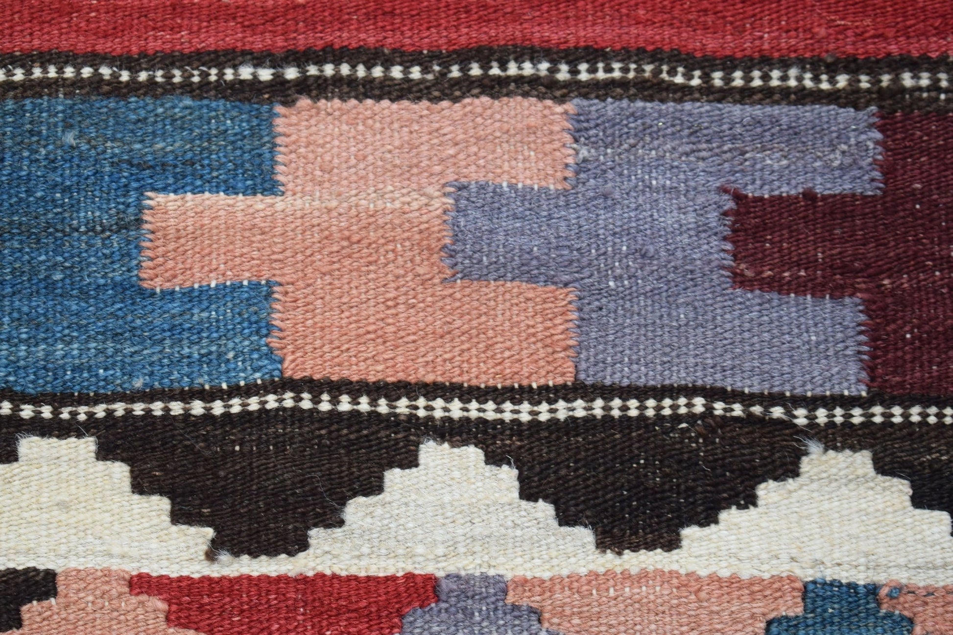 A close-up of a handmade Afghan Maimana kilim runner featuring geometric patterns in wool.