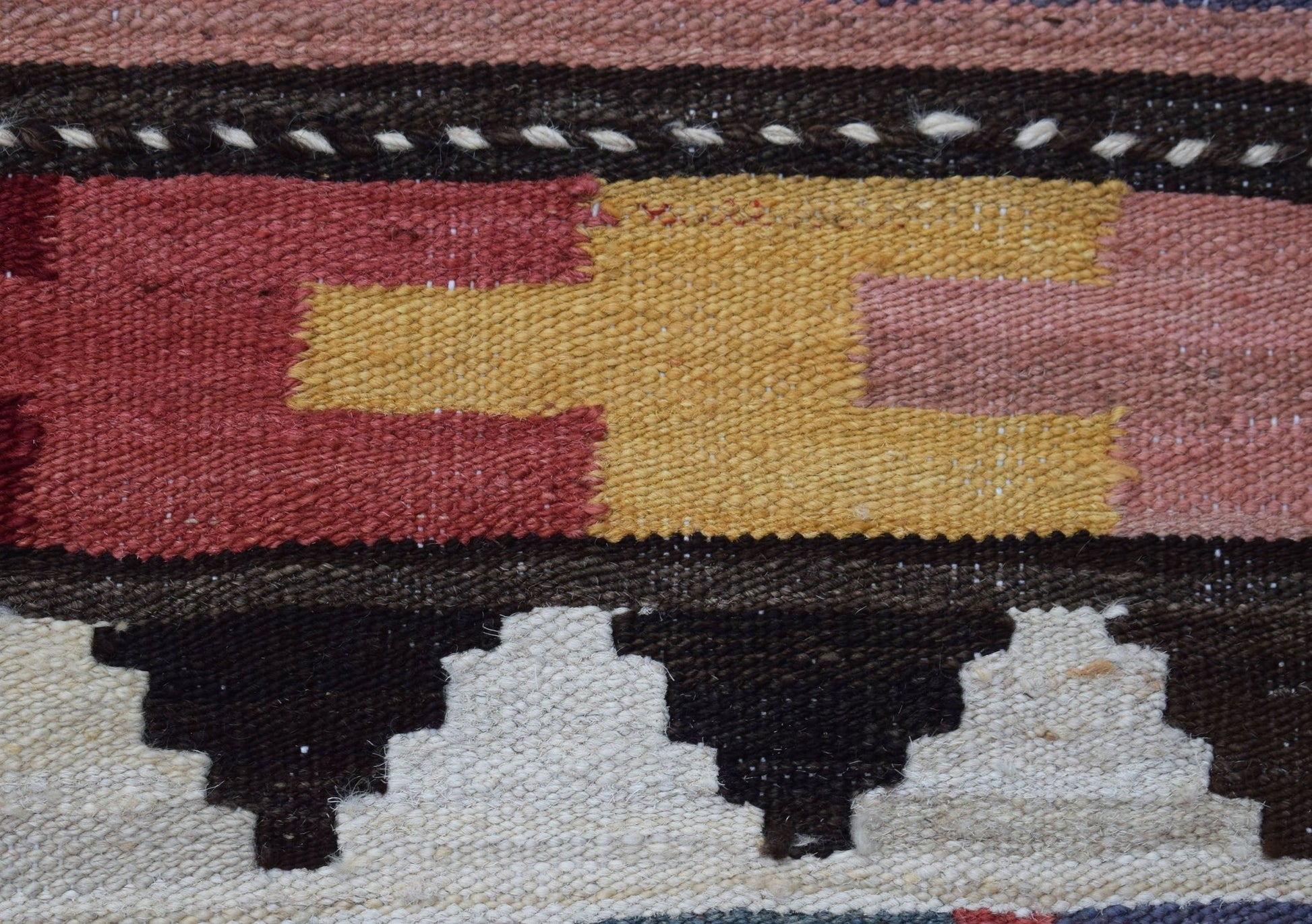 A close-up of a handmade Afghan Maimana kilim runner featuring geometric patterns in wool.