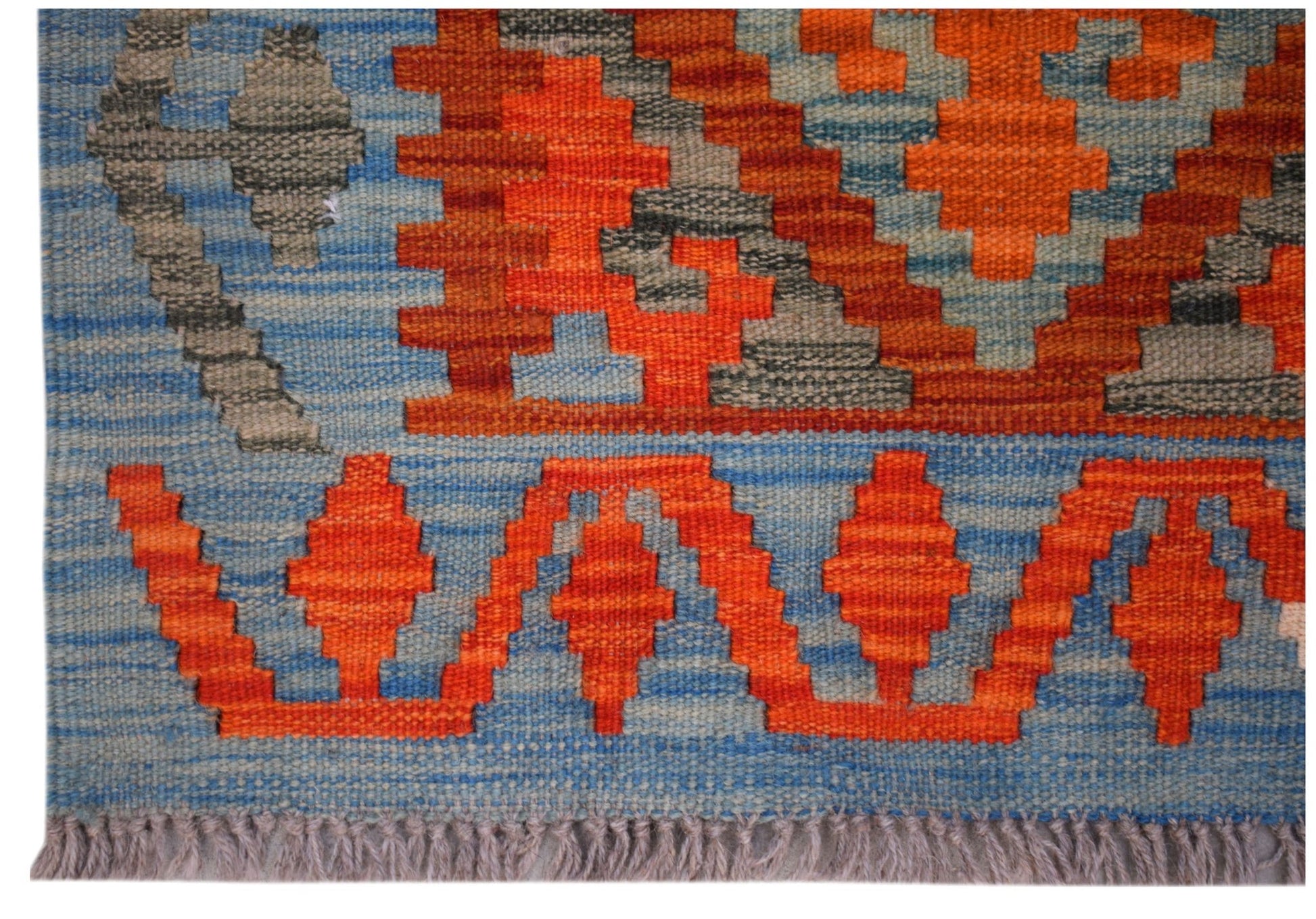 Handwoven Afghan Maimana kilim runner featuring geometric orange and grey patterns on a blue field.