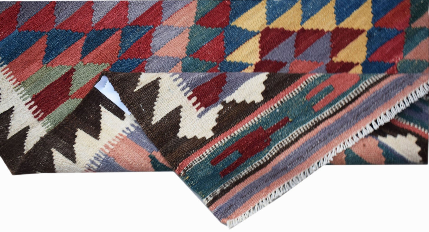A handwoven Afghan Maimana wool kilim runner featuring geometric patterns in vibrant colors.