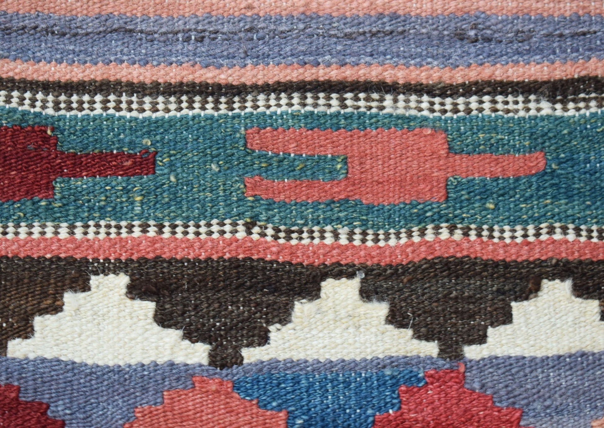 A close-up of a handmade Afghan Maimana kilim runner featuring geometric patterns in wool.