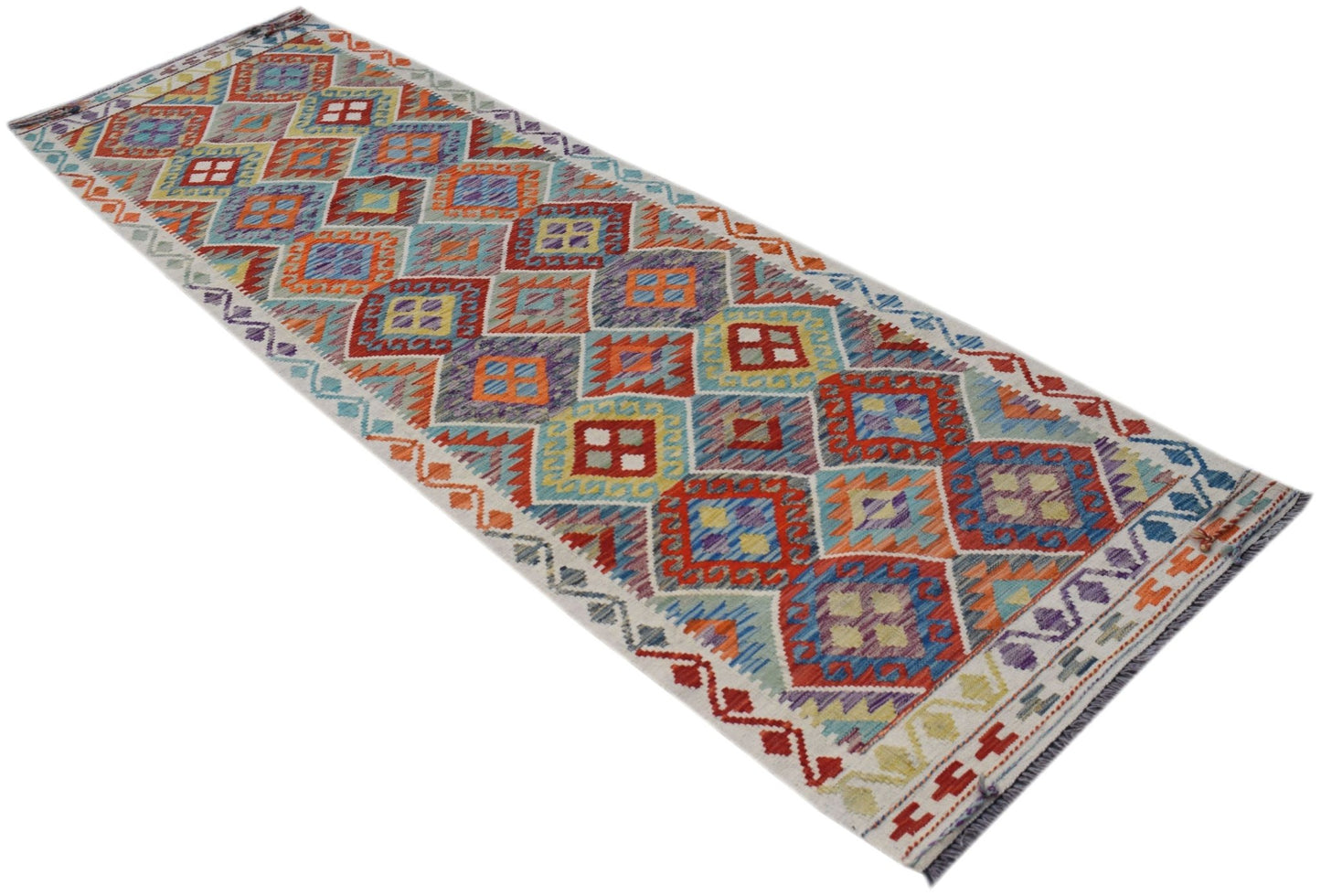 A handmade Afghan Maimana wool runner rug featuring a colorful geometric diamond pattern.