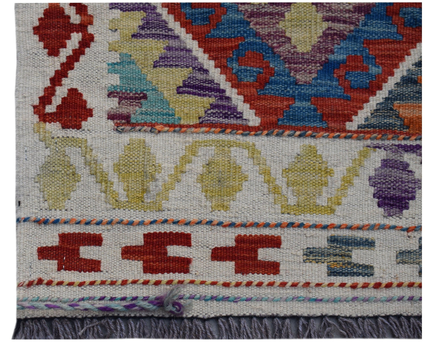 A handwoven Afghan Maimana kilim runner featuring geometric patterns in vibrant, multicolored wool.