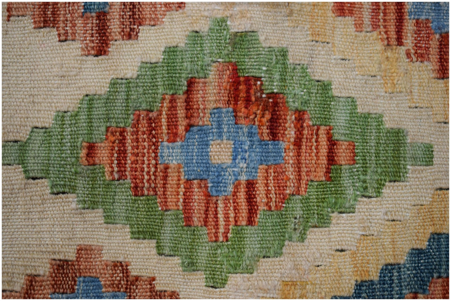 A close-up of a handmade Afghan Maimana kilim runner featuring a geometric diamond pattern.