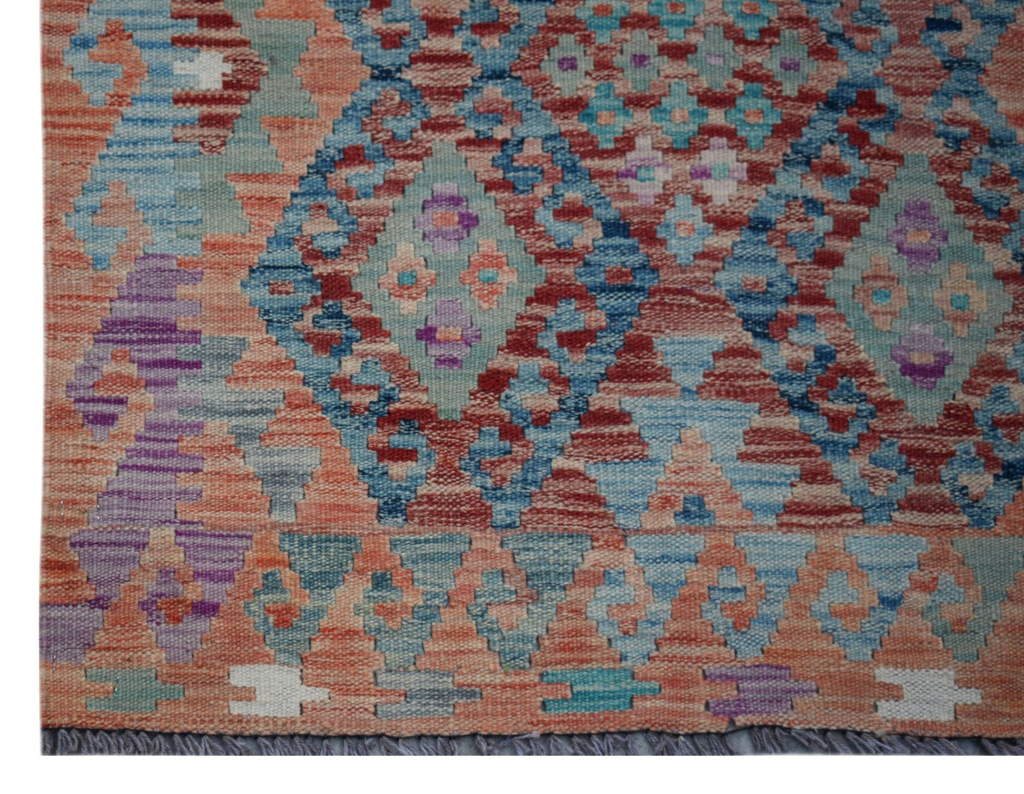 Handwoven Afghan Maimana wool runner featuring a geometric diamond pattern in vibrant colors.