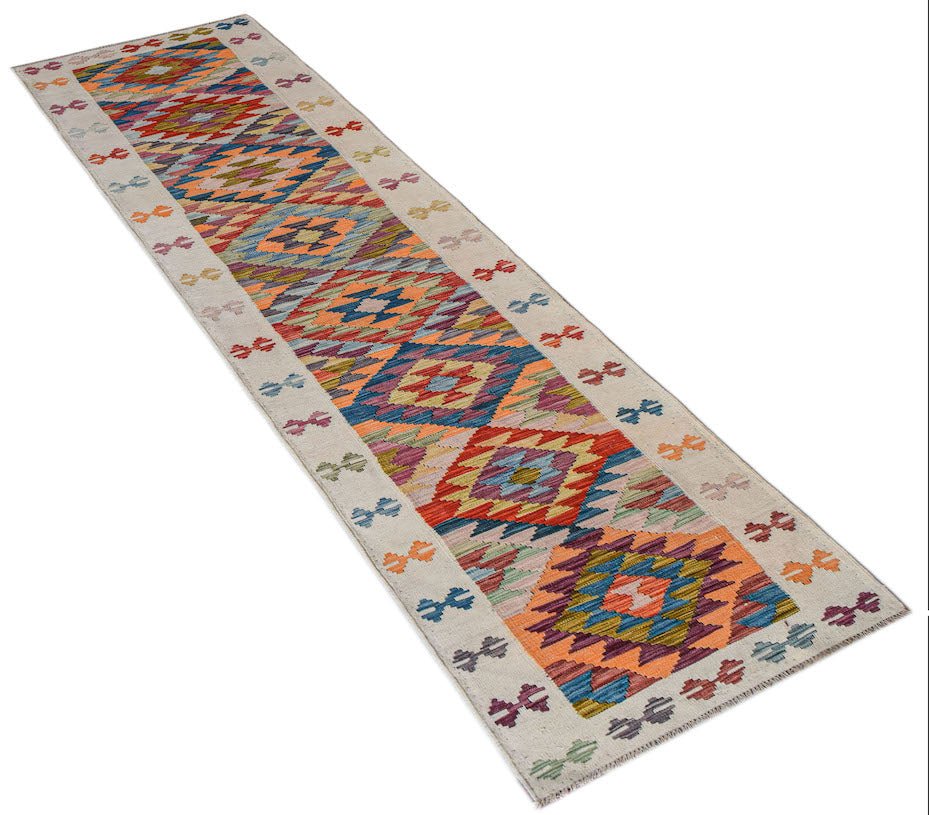 A long, handmade Afghan Maimana wool runner rug featuring a colorful geometric diamond pattern.