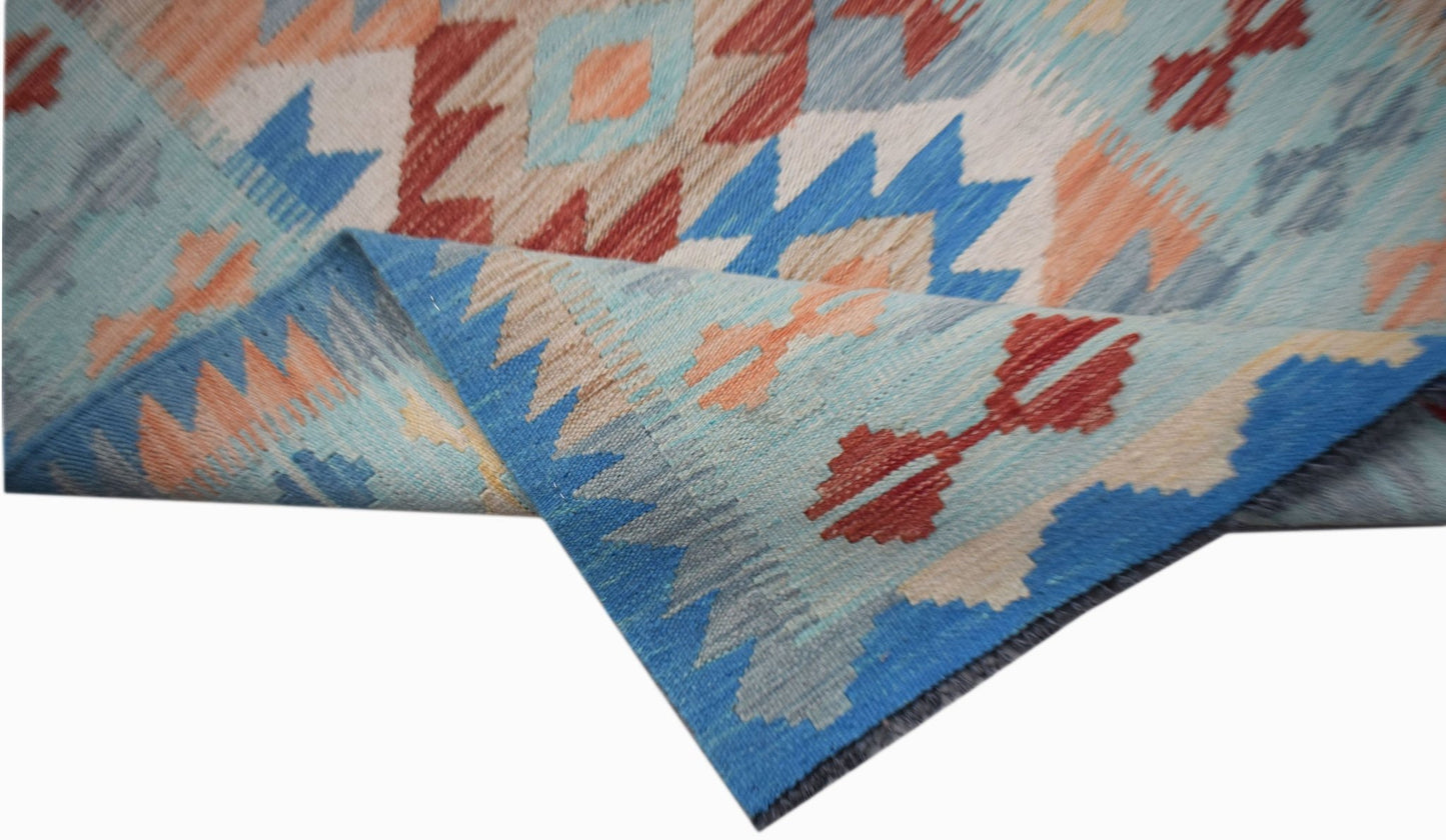 A handmade Afghan Maimana wool kilim runner featuring a geometric pattern in blue, red, and tan.