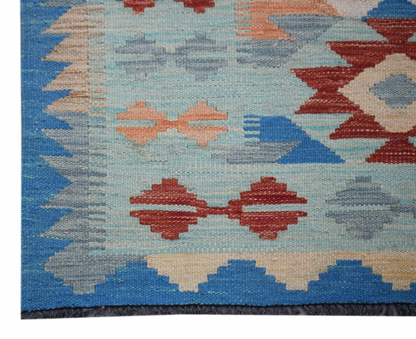 Handwoven Afghan Maimana wool runner featuring geometric patterns in blue, red, and beige.