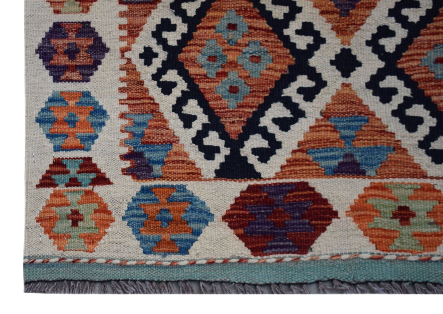 Handwoven Afghan Maimana kilim runner featuring geometric patterns in vibrant wool colors.