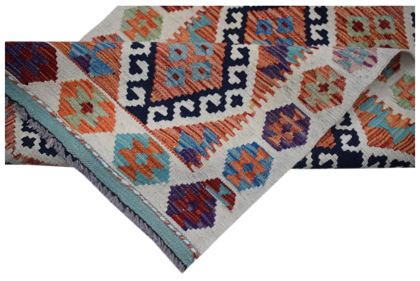 A handwoven Afghan Maimana wool runner featuring a colorful geometric pattern on a cream background.