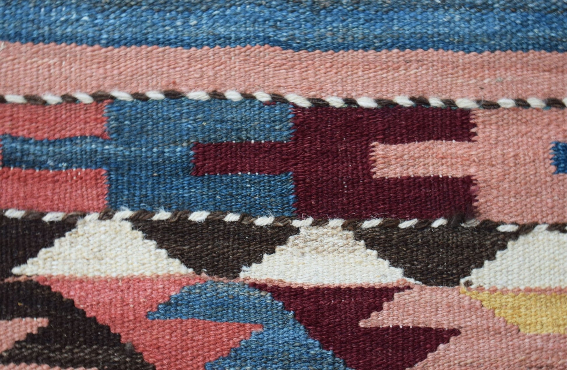 A close-up of a handmade Afghan Maimana kilim runner featuring geometric patterns in wool.