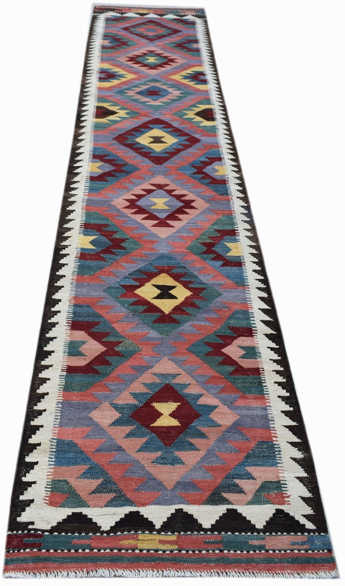 A long, handmade Afghan Maimana wool runner featuring a colorful geometric diamond pattern.