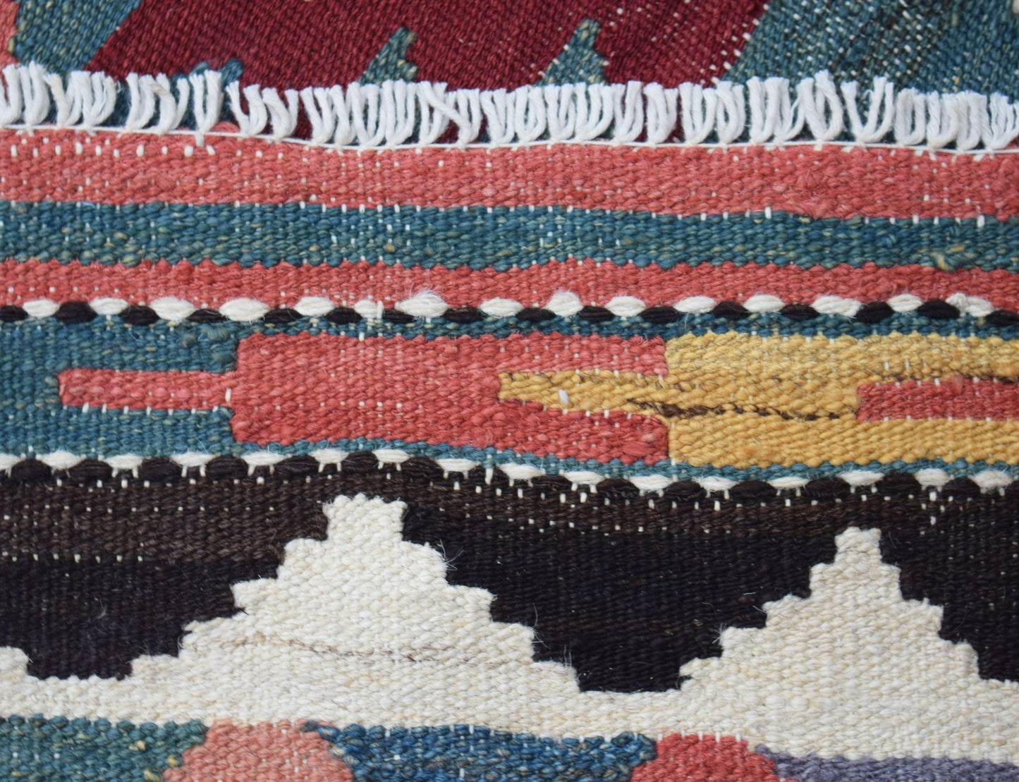 A close-up of a handmade Afghan Maimana kilim runner featuring geometric patterns and wool texture.