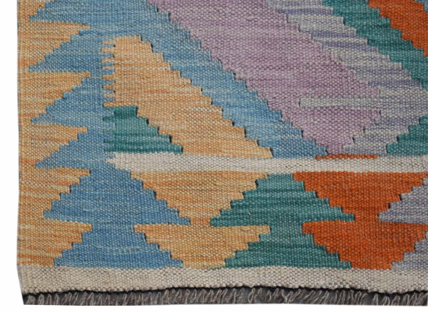 A handmade Afghan Maimana Kilim runner featuring a geometric pattern in vibrant, multicolored wool.