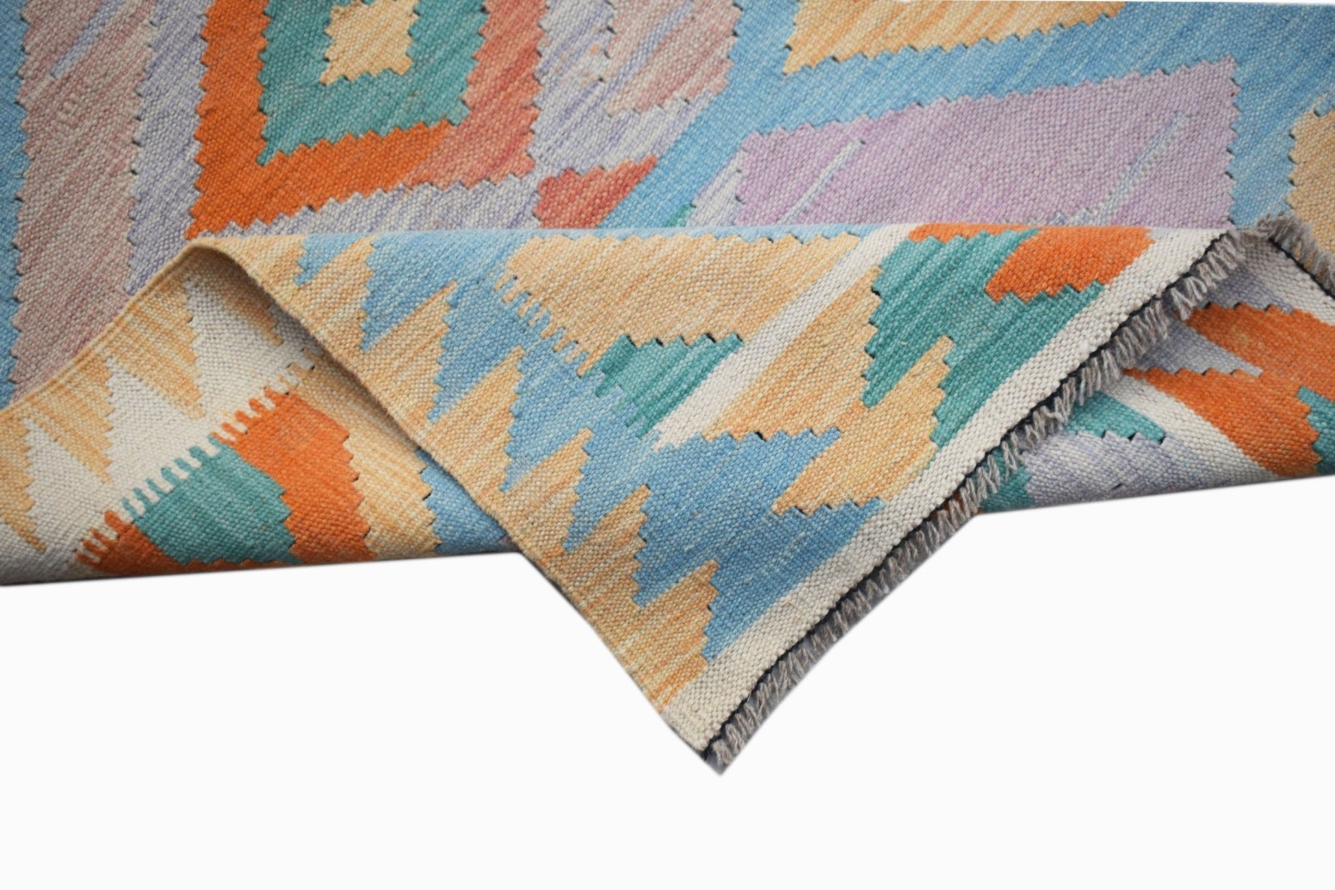 A handmade Afghan Maimana kilim runner featuring a geometric pattern in orange, blue, and cream.