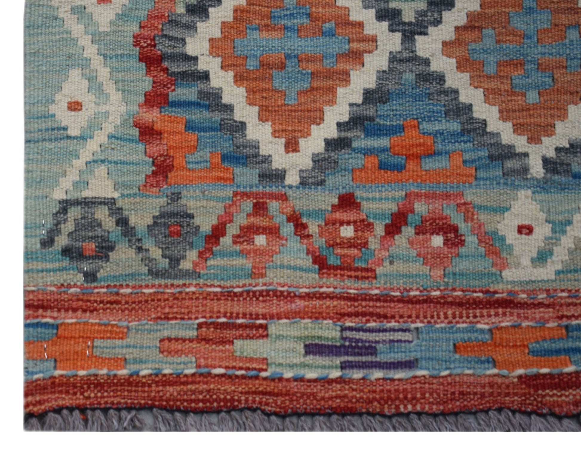 A handmade Afghan Maimana Kilim runner featuring geometric patterns in blue, orange, and red wool.