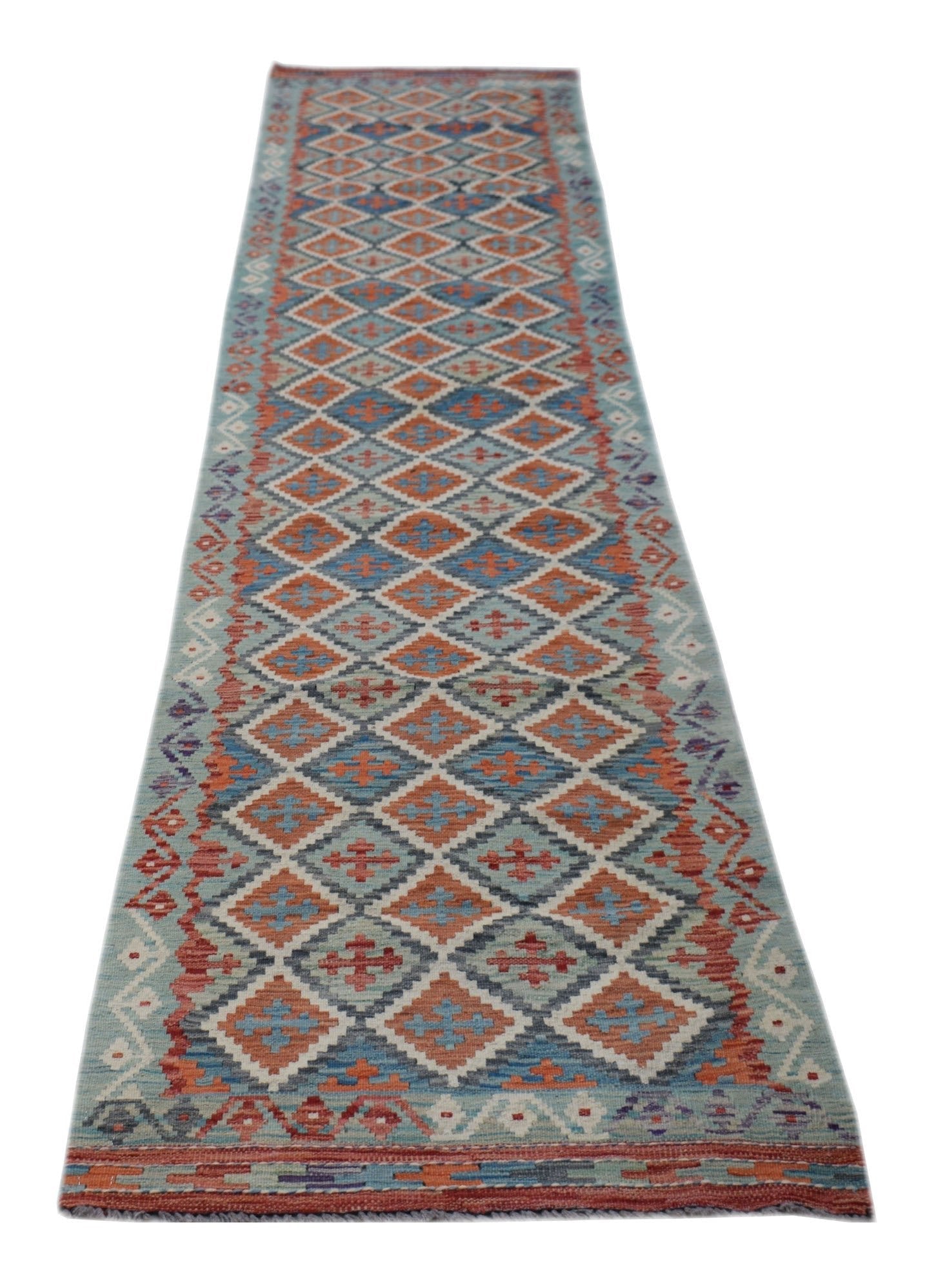 A handmade Afghan Maimana wool runner rug featuring a repeating diamond pattern in blue and orange.