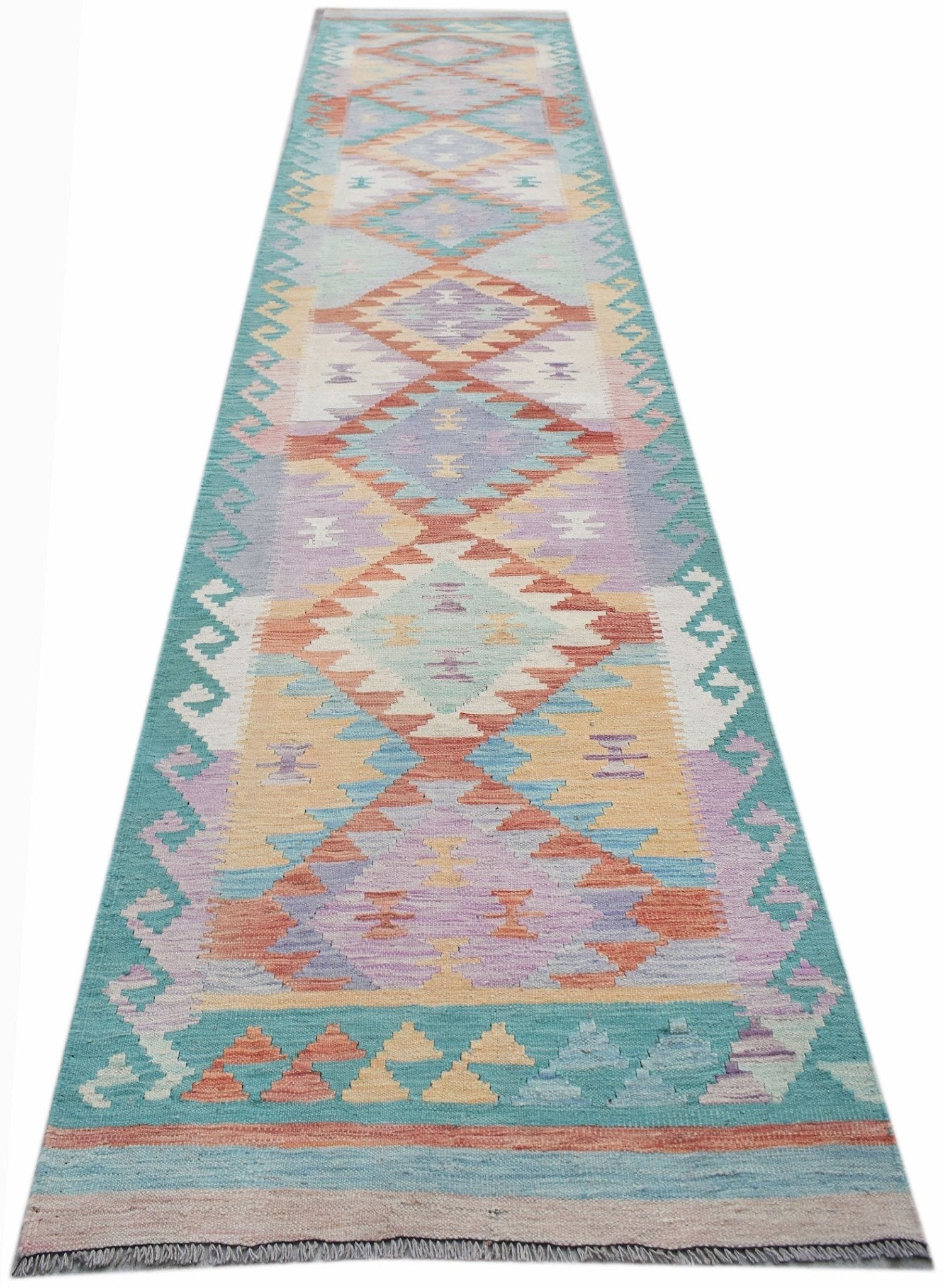 A handmade Afghan Maimana wool runner rug featuring a colorful geometric diamond pattern.