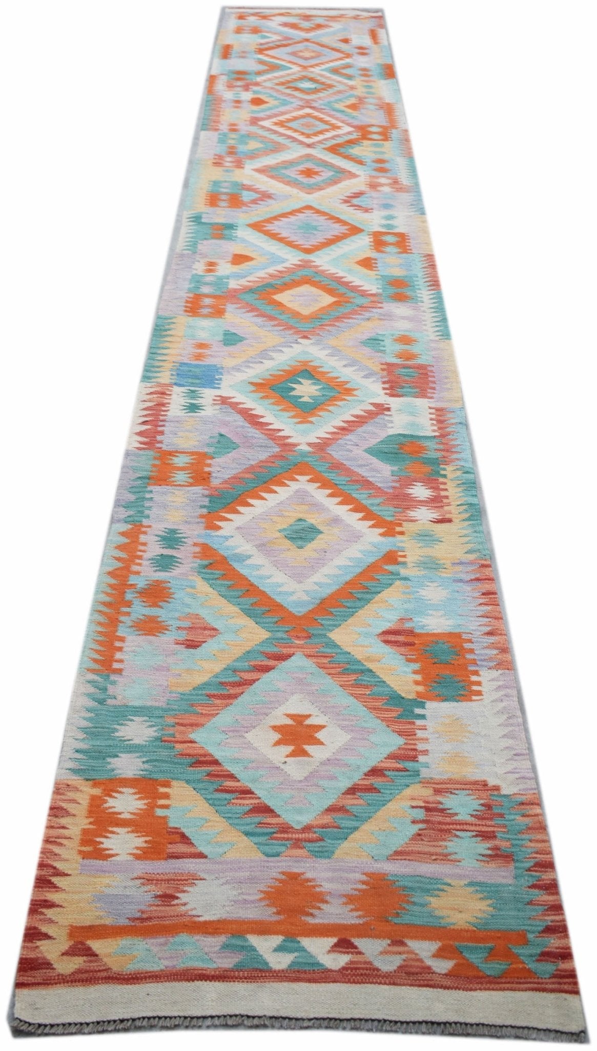 A long, handmade Afghan Maimana wool runner featuring a colorful geometric diamond pattern.