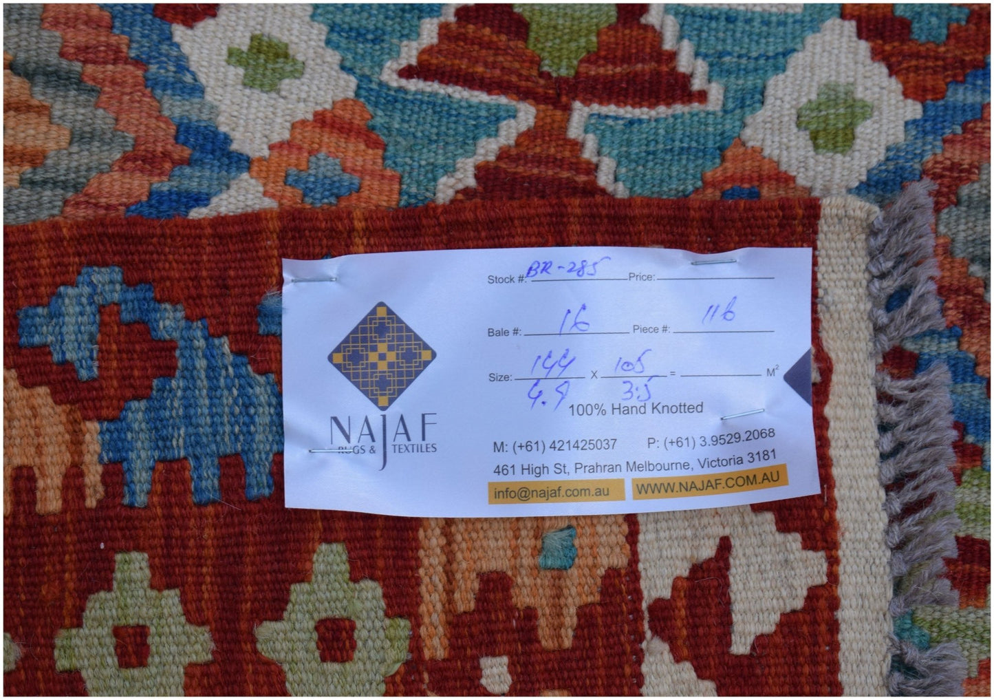 A handwoven Afghan Maimana kilim featuring a geometric pattern in red, blue, and cream tones.